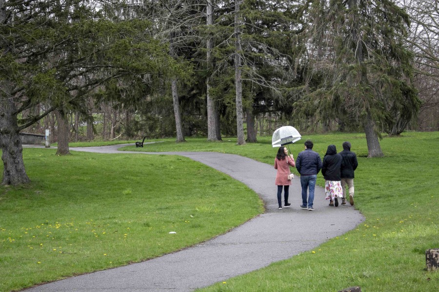 Liane Lemos from Brazil, and Marco Santillo from Italy, and friends walking in the rain alone the Niagara Parkway on Sunday, May 1. (Richard Harley)