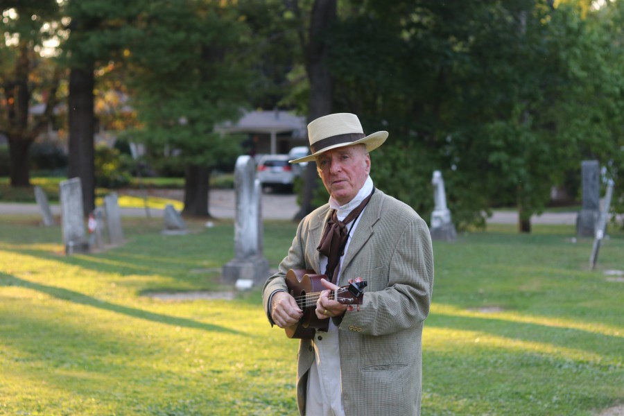 Geoff Senson as Willie Blain plays some tunes during a theatrical cemetery tour. (Dariya Baiguzhiyeva/Niagara Now)